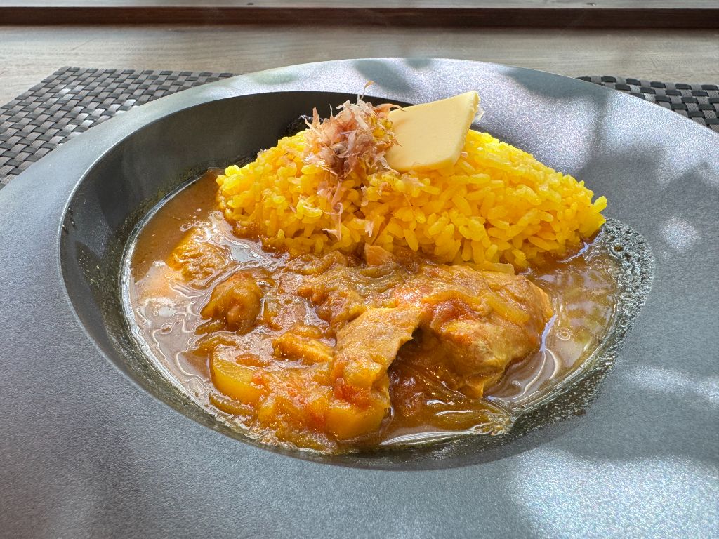ハーブチキンスパイスカレー。鶏肉の入ったカレーにバター醤油ライスを合わせた一皿