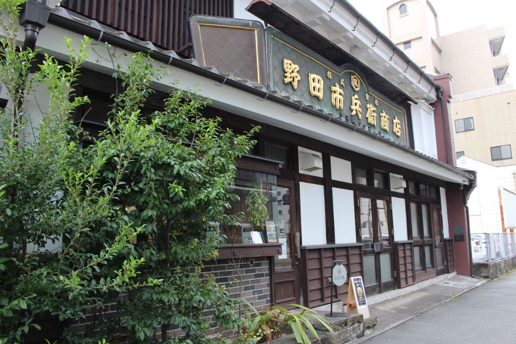 市カレーが入る野田市兵衞商店の歴史ある木造建物。金文字の看板が目印